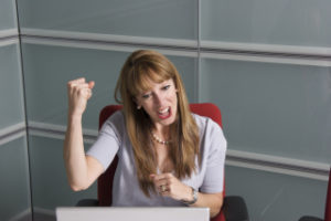 Woman cheering at her desk