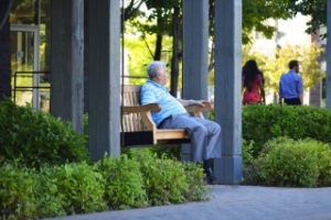 An elderly person sitting on a bench