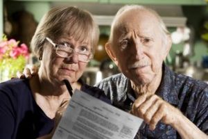 Two senior citizens with paperwork 
