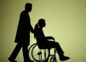 image of man pushing wheelchair with woman