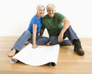 Two people on the floor with house plans