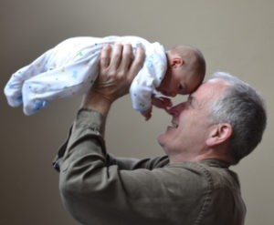 Senior man holding a baby