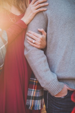 A couple holding onto one another in an engagement like photo