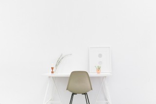 A white desk in a white room