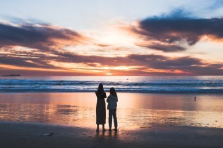 two people overlooking an ocean sunset