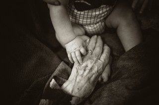 elderly hand holding a toddler's hand