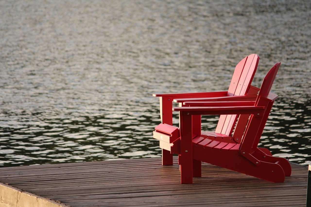 two chairs sitting on a dock on the water