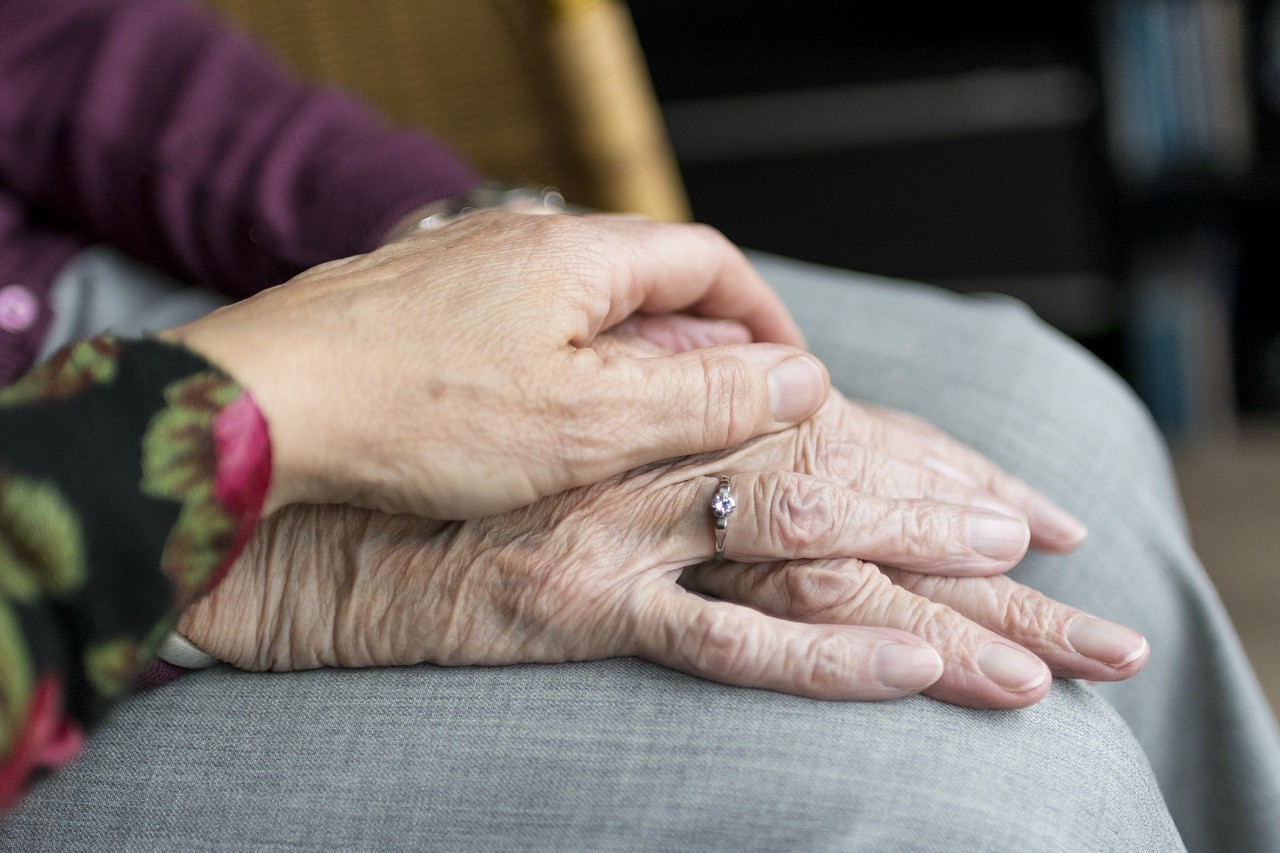a hand holding an elderly woman's hand