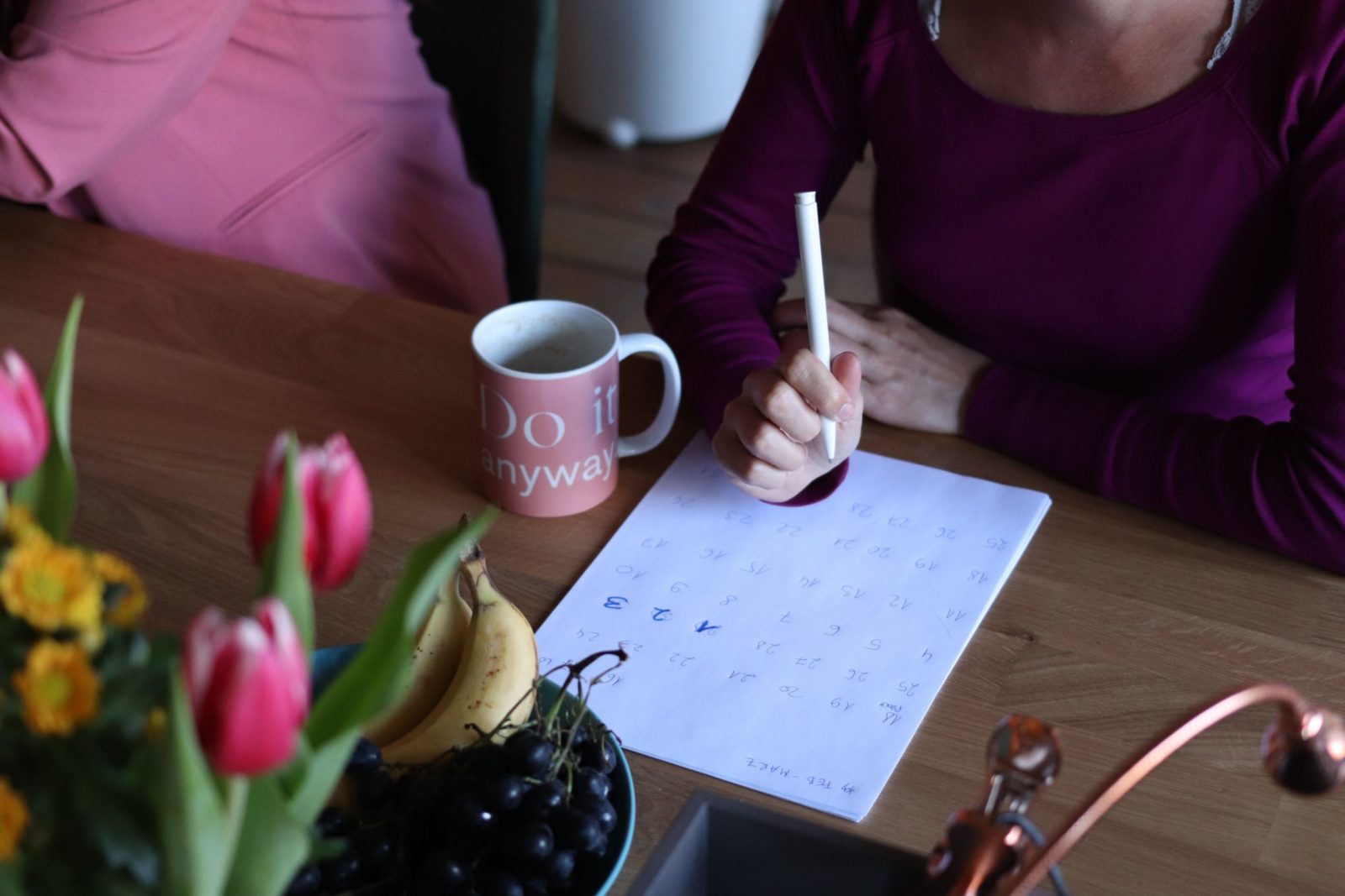 woman at a table with coffee and calendar