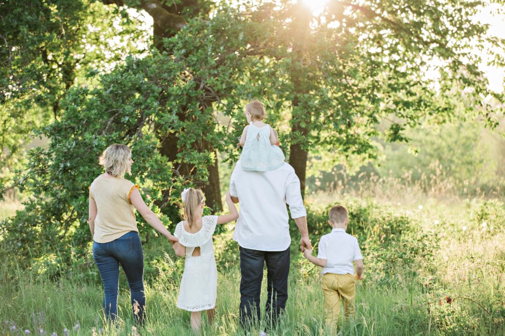 family walking in a field of grass together