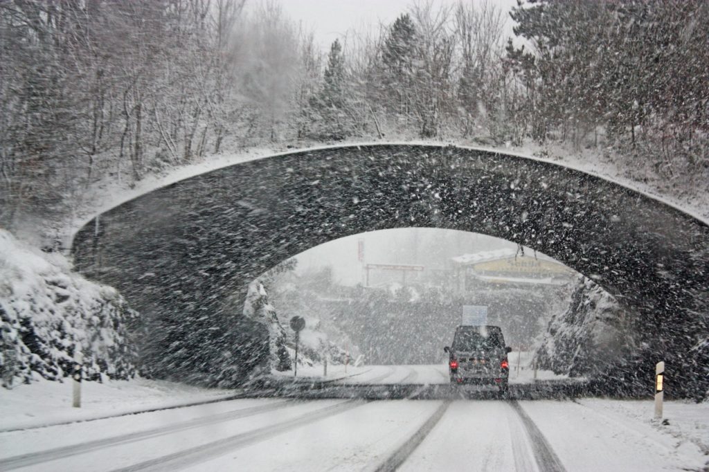 snowstorm with a bridge and car