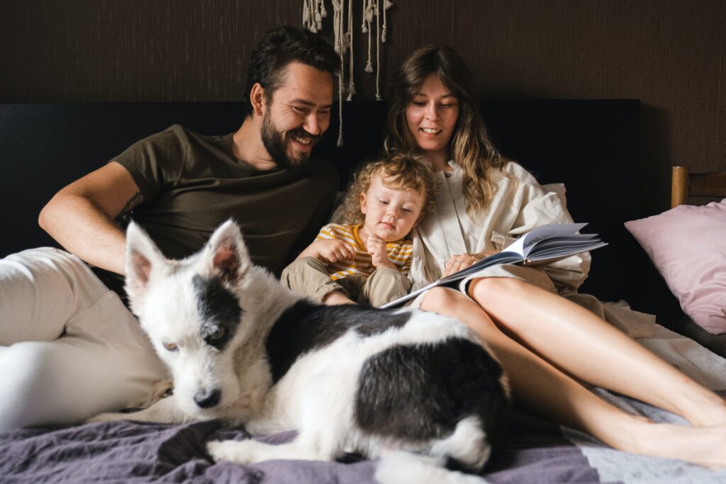 family with dog in bed